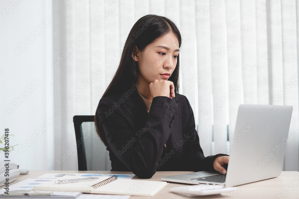 Asian businesswomen sit at their desks and calculate financial graphs showing results about their investments, plan a successful business growth process in the office Asian businesswomen sit at their desks and calculate financial graphs showing results about their investments, plan a successful business growth process in the office