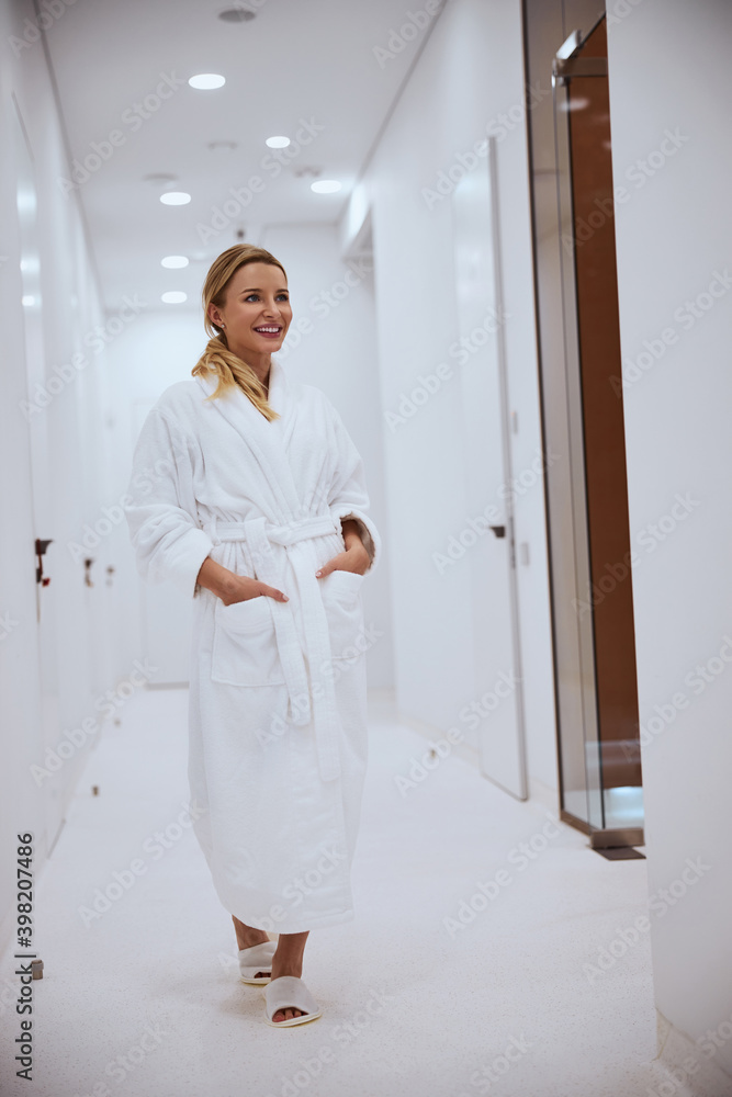 Spa client in a terry bathrobe walking ahead