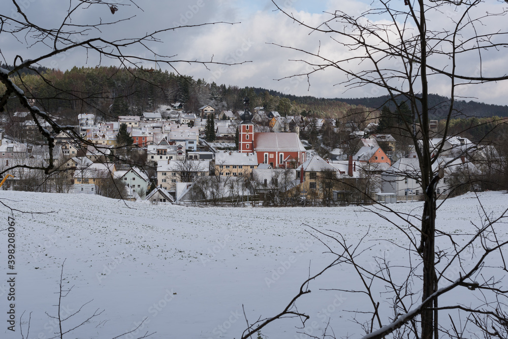 Scenic view of the small town Etzelwang in Bavaria with snow-covered roofs and church in winter