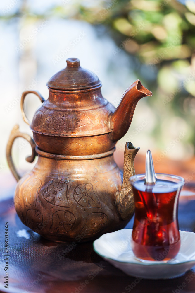 Drinking Traditional Turkish Tea with tea cup and copper tea pot. Drinking Traditional Turkish Tea with tea cup and copper tea pot.