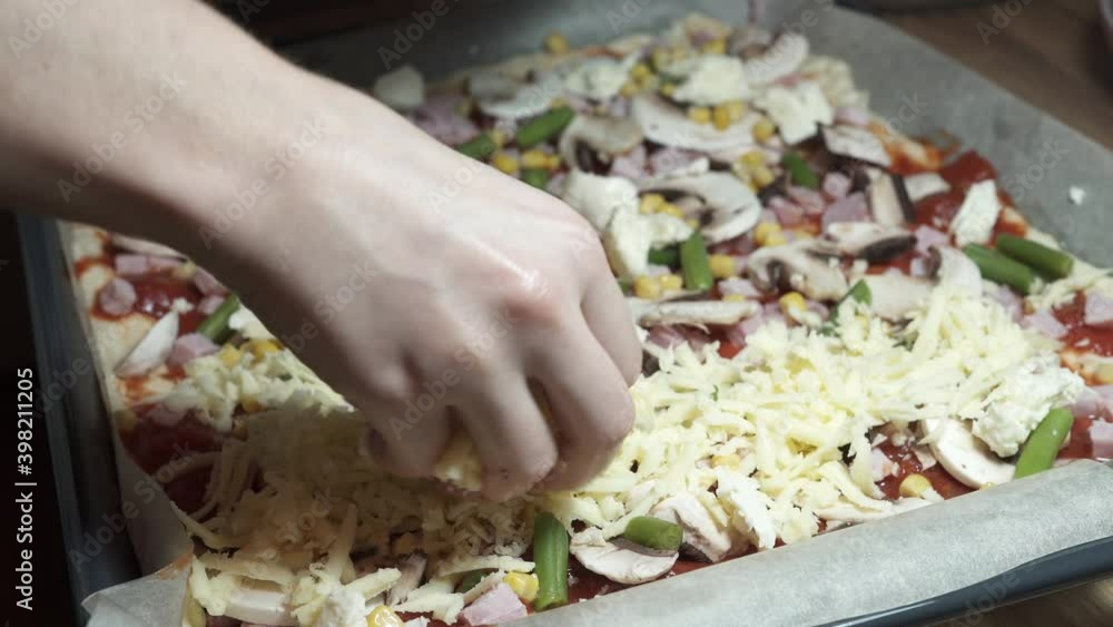 Woman preparing Homemade pizza, add cheese. Ham, mushrooms, mozzarella, and tomato sauce. Healthy food. Italian cuisine. Tasty concept. Home isolation food Woman preparing Homemade pizza, add cheese. Ham, mushrooms, mozzarella, and tomato sauce. Healthy food. Italian cuisine. Tasty concept. Home isolation food