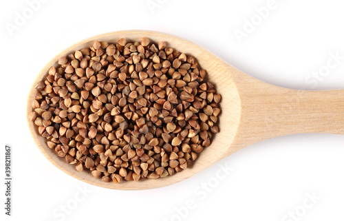 Buckwheat seeds in wooden spoon isolated on white background, top view