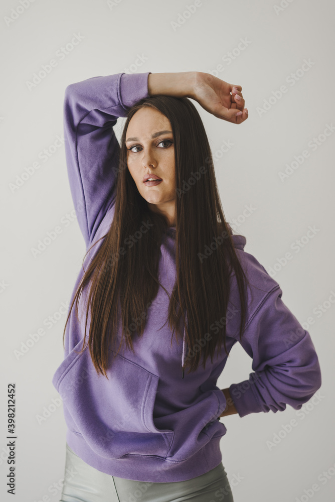Portrait of young woman with long straight hair dressed in purple hoodie. Sport outfit Portrait of young woman with long straight hair dressed in purple hoodie. Sport outfit