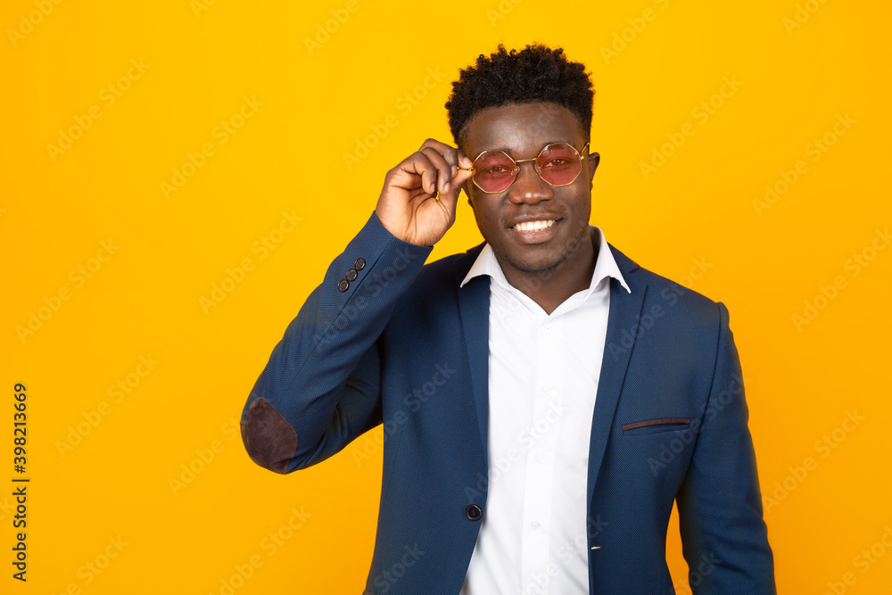 handsome african man in jacket and sunglasses on yellow background handsome african man in jacket and sunglasses on yellow background
