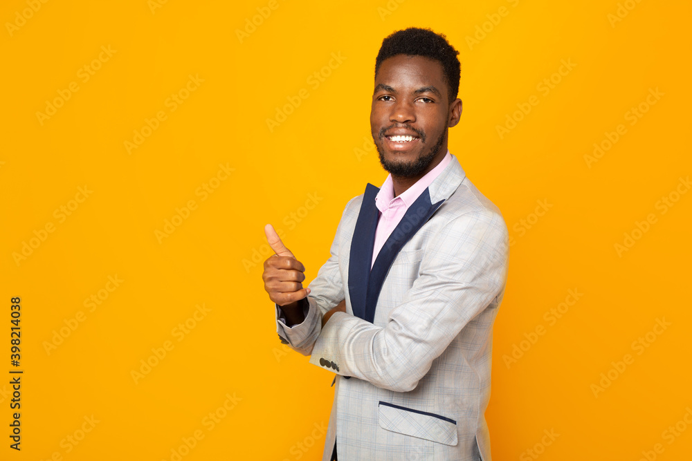 handsome african man in jacket on yellow background with hand gesture handsome african man in jacket on yellow background with hand gesture