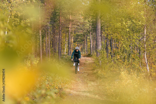 Professional athletic road cyclist ride carbon gravel bike of beautiful autumn forest trail. Cycling exploration adventure or ultra endurance long distance race. Amazing autumn foliage 