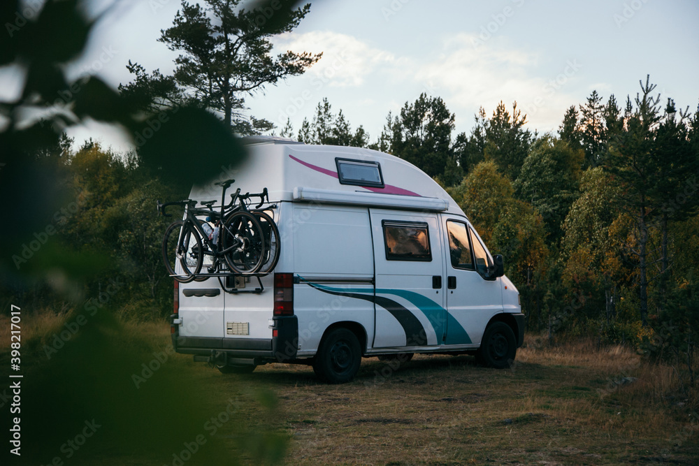 Cute adorable vintage van, customised for camping purposes, parked in stealth wild spot for overnight adventure. Vanlife nomadic lifestyle popular with millennials. New holidays destination trend