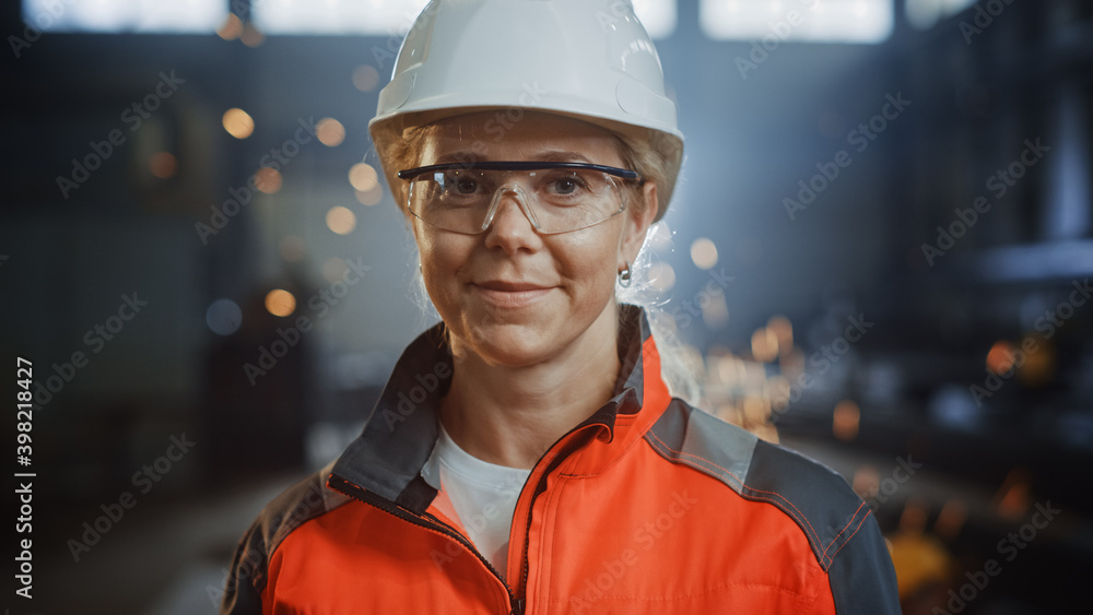 Portrait of a Professional Heavy Industry Engineer Worker Wearing Uniform, Glasses and Hard Hat in a Steel Factory. Beautiful Female Industrial Specialist Standing in Metal Construction Facility. - obrazy, fototapety, plakaty 