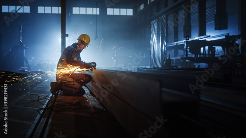 Canvas Print Heavy Industry Engineering Factory Interior with Industrial Worker Using Angle Grinder and Cutting a Metal Tube