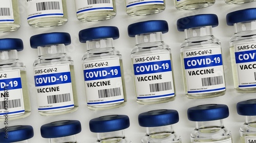 Viele Fläschchen Corona Impfstoff von oben auf weißem Untergrund photo