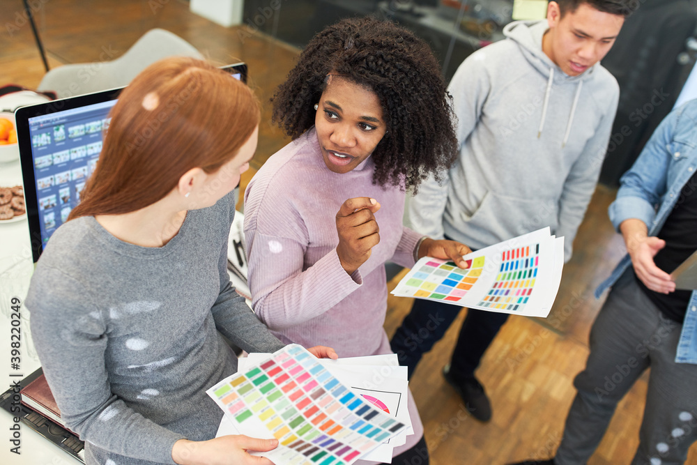 African graphic designer discusses with colleague Stock Photo Adobe Stock