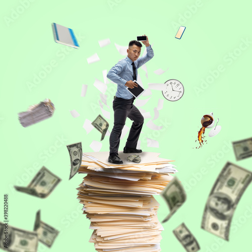 Office worker, businessman, sportsman fighting with deadlines standing on the bunch of documents with flying money. Modern business and finance, sport, time, creative artwork, contemporary design.