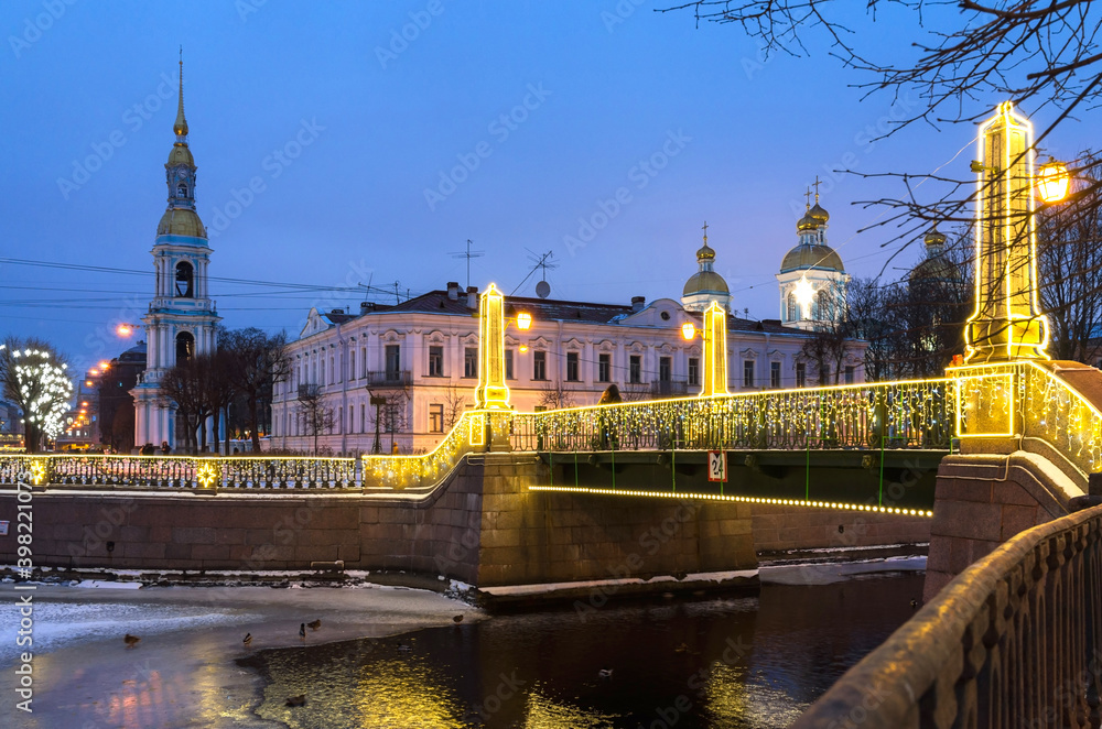 Saint Petersburg in Christmas holidays. People take pictures on mobile phones of festively decorated bridges in the place of Seven Bridges in the New Year's lighting.  Festive cityscape
