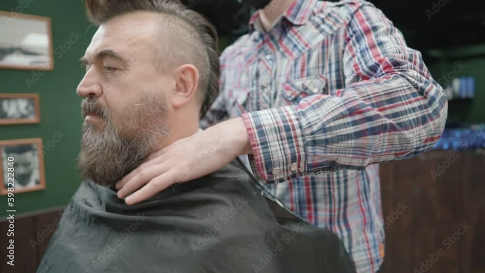 Hairdresser prepares the client for a beard cut. Close-up. Hairdresser prepares the client for a beard cut. Close-up.
