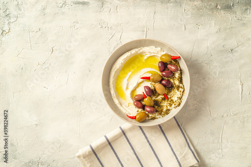 Popular middle eastern appetizer labneh or labaneh, soft white goat milk cheese with olive oil, hyssop or zaatar, served with pita bread over grey table, flaylay. photo