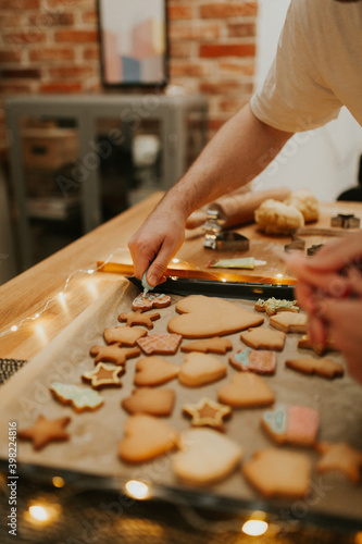 Christmas baking. Cooking Christmas gingerbread. Damily decorating freshly baked cookies with icing  close up. Festive food  family culinary  Christmas and New Year traditions concept