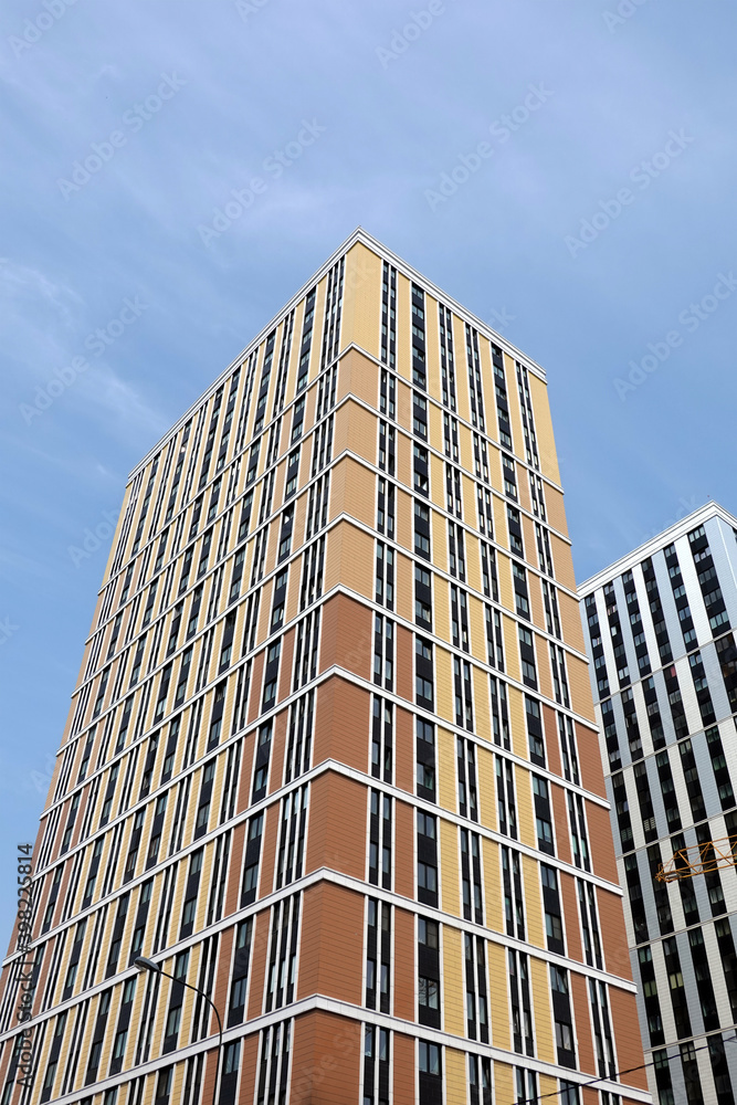 Fototapeta premium High bottom up perspective view of modern city skyscraper buildings with many windows in the urban cluster