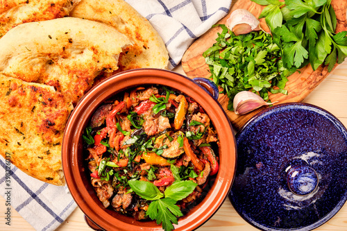 Ajapsandal. Traditional Georgian appetizer cooked from aubergine,pepper, onion, carrot, tomato, garlic, basil, parsley and different sorts of herbs and spices in а clay blue casserole dish with bread.