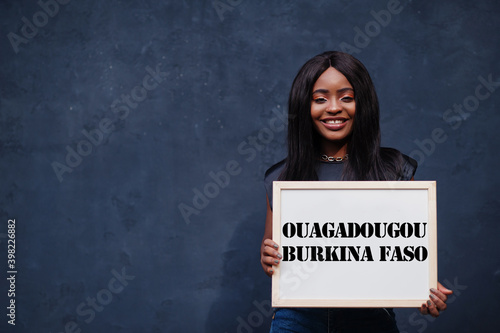 African woman hold white board with Ouagadougou Burkina Faso inscription. Most populous city in Africa concept. photo