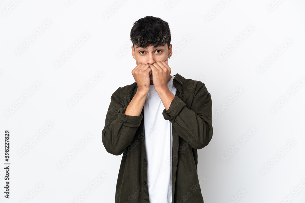 Young man over isolated white background nervous and scared putting hands to mouth Young man over isolated white background nervous and scared putting hands to mouth