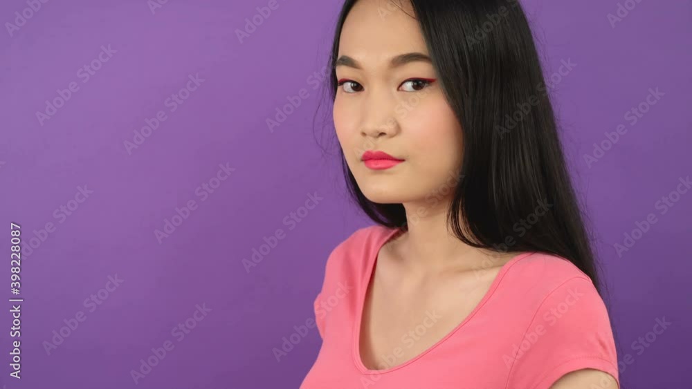 close-up three quarter portrait of young asian woman on isolated purple background 4K close-up three quarter portrait of young asian woman on isolated purple background 4K