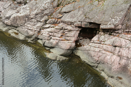 A cave in a rock on the riverbank
