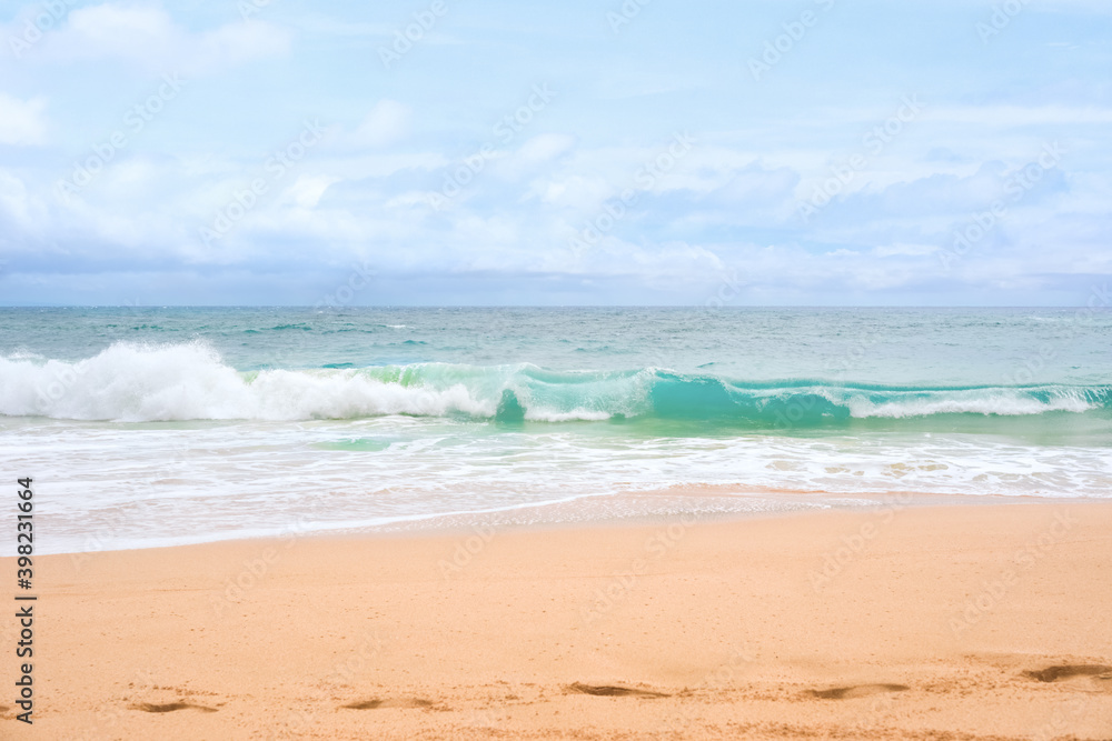 Beautiful blue green aqua waves of the Pacific ocean as it breaks onto beach 