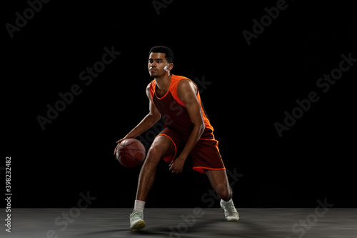 Winner. Young purposeful african-amrican basketball player training, practicing in action, motion isolated on black background. Concept of sport, movement, energy and dynamic, healthy lifestyle. © master1305