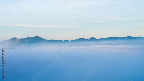 Many houses in in the mist in the morning. Early morning fog and mist burns off over large houses nestled in green rolling hills