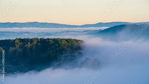 Many houses in in the mist in the morning. Early morning fog and mist burns off over large houses nestled in green rolling hills © Nhan