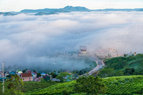 Many houses in in the mist in the morning. Early morning fog and mist burns off over large houses nestled in green rolling hills