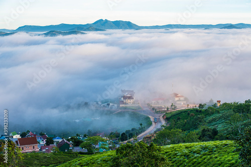 Many houses in in the mist in the morning. Early morning fog and mist burns off over large houses nestled in green rolling hills © Nhan