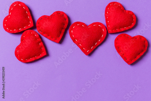 Composition of textile red hearts on colorful background with empty space for your design. Top view of St. Valentine s day concept