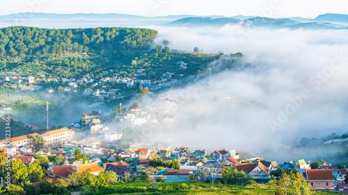 Many houses in in the mist in the morning. Early morning fog and mist burns off over large houses nestled in green rolling hills