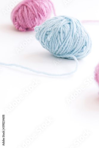 Two skeins of multi-colored woolen yarn on a light background with copy space. Close up