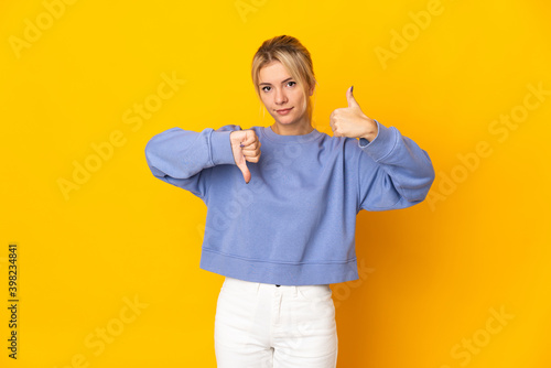 Tableau sur toile Young Russian woman isolated on yellow background making good-bad sign