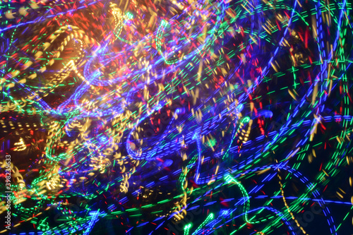 Fototapeta Naklejka Na Ścianę i Meble -  Bright multicolored Christmas lights shot on long exposure in motion against a black background. a large number of lights, bokeh. Horizontal photo.