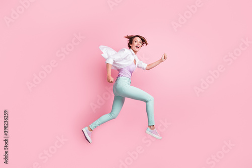 Full body portrait of jumping running lady enjoy activity open mouth good mood isolated on pink color background