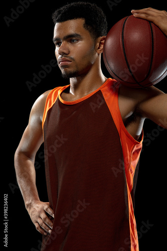 Strong. Young purposeful african-amrican basketball player training, practicing in action, motion isolated on black background. Concept of sport, movement, energy and dynamic, healthy lifestyle. © master1305