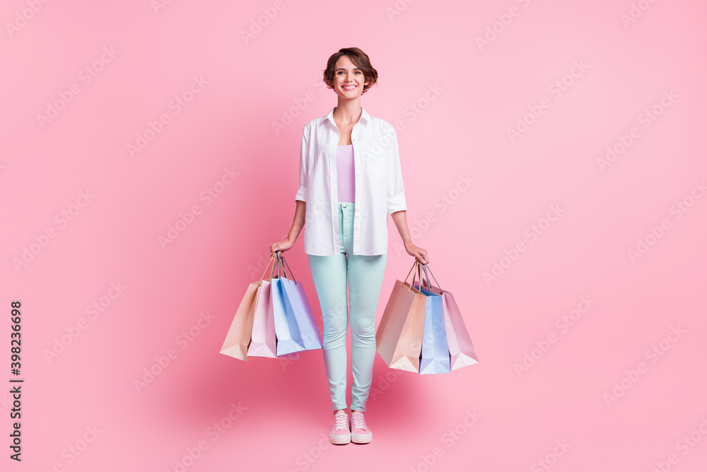 Full size portrait of satisfied person hands hold bags after shopping isolated on pink color background Full size portrait of satisfied person hands hold bags after shopping isolated on pink color background