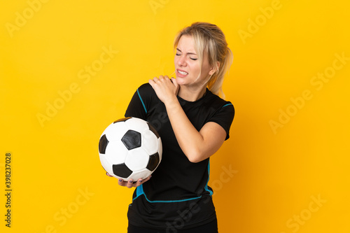 Young Russian football player woman isolated on yellow background suffering from pain in shoulder for having made an effort © luismolinero