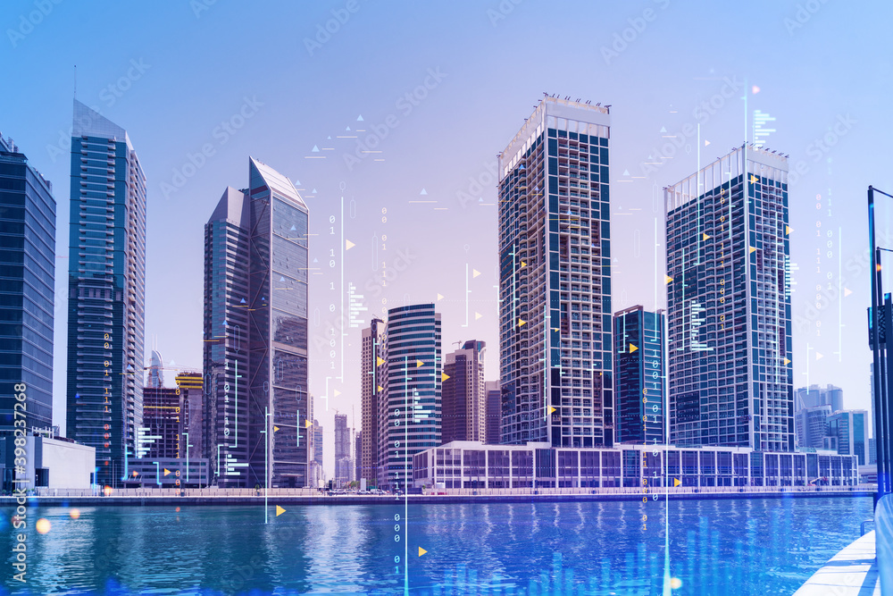 Fototapeta premium Skyscrapers of Dubai business downtown. International hub of trading and financial services of Western Asia. FOREX graph and chart concept. Double exposure. Dubai Canal waterfront.