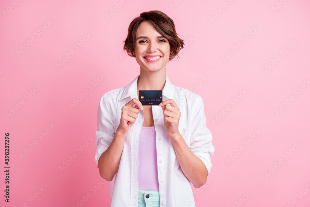 Photo of adorable sweet young lady wear white shirt holding hands arms bank card isolated pink color background Photo of adorable sweet young lady wear white shirt holding hands arms bank card isolated pink color background
