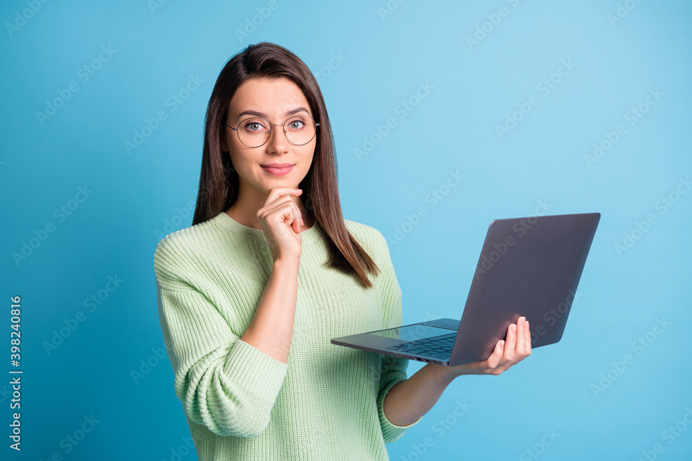 Photo of intelligent ceo worker girl hold laptop touch fingers chin isolated over blue color background Photo of intelligent ceo worker girl hold laptop touch fingers chin isolated over blue color background