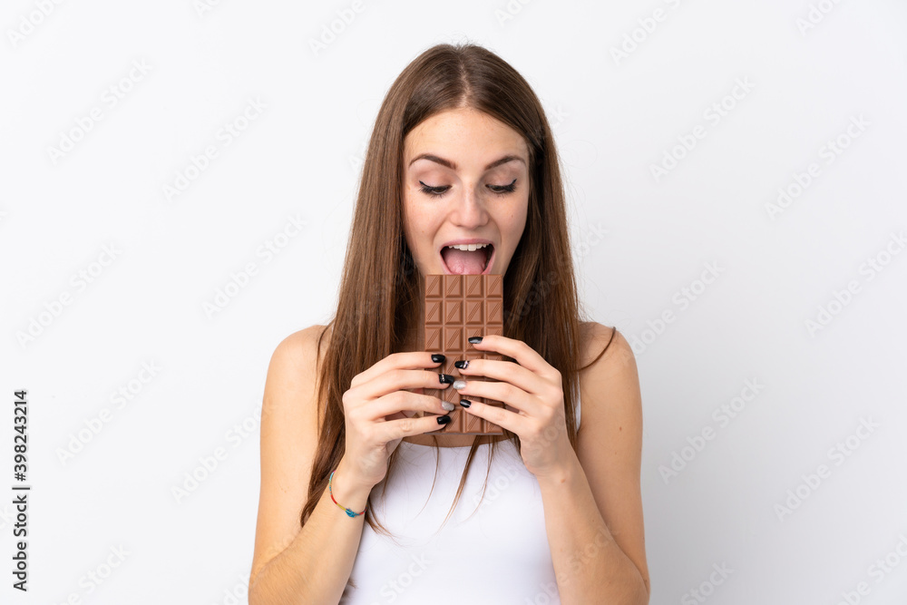Young woman over isolated white background eating a chocolate tablet Young woman over isolated white background eating a chocolate tablet