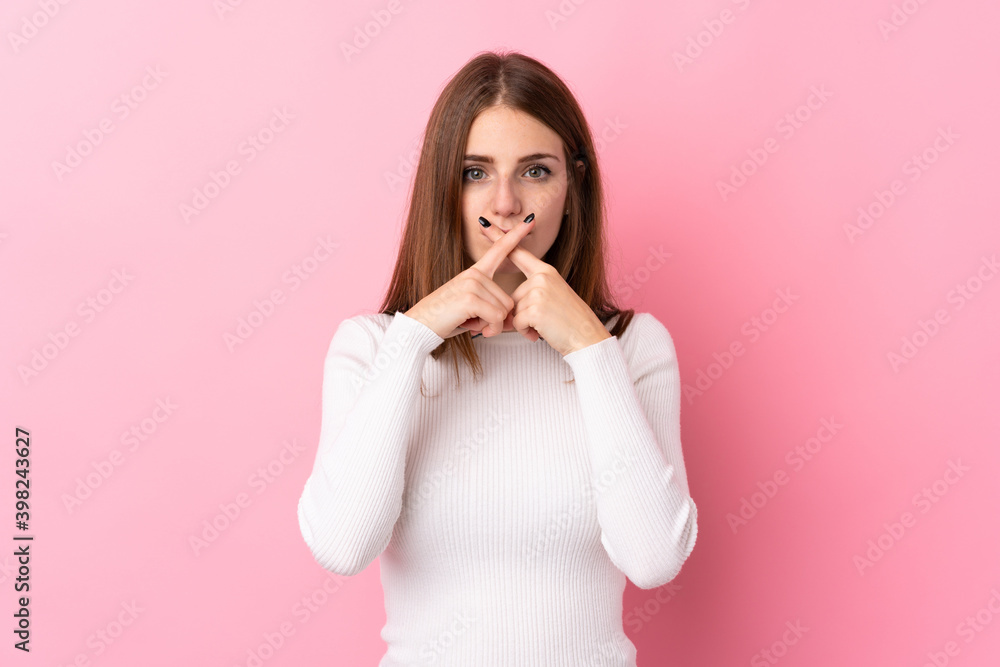 Young woman over isolated pink background showing a sign of silence gesture Young woman over isolated pink background showing a sign of silence gesture