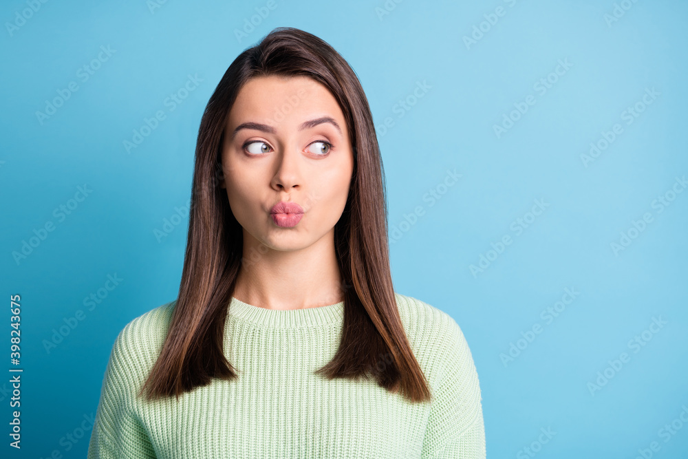 Photo of pretty young girl send air kiss look empty space wear green sweater isolated blue color background Photo of pretty young girl send air kiss look empty space wear green sweater isolated blue color background