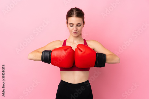 Young sport woman over isolated pink background with boxing gloves © luismolinero