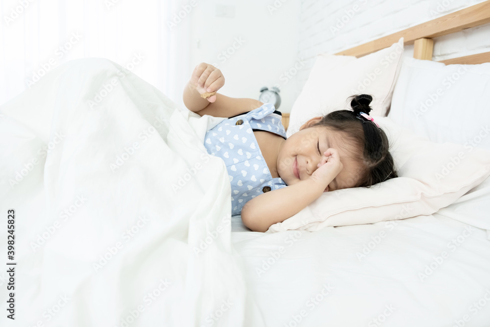 Cute little Asian toddler girl tired and sleepy in bed
