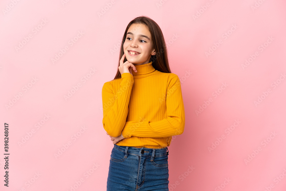 Little girl isolated on pink background thinking an idea while looking up Little girl isolated on pink background thinking an idea while looking up